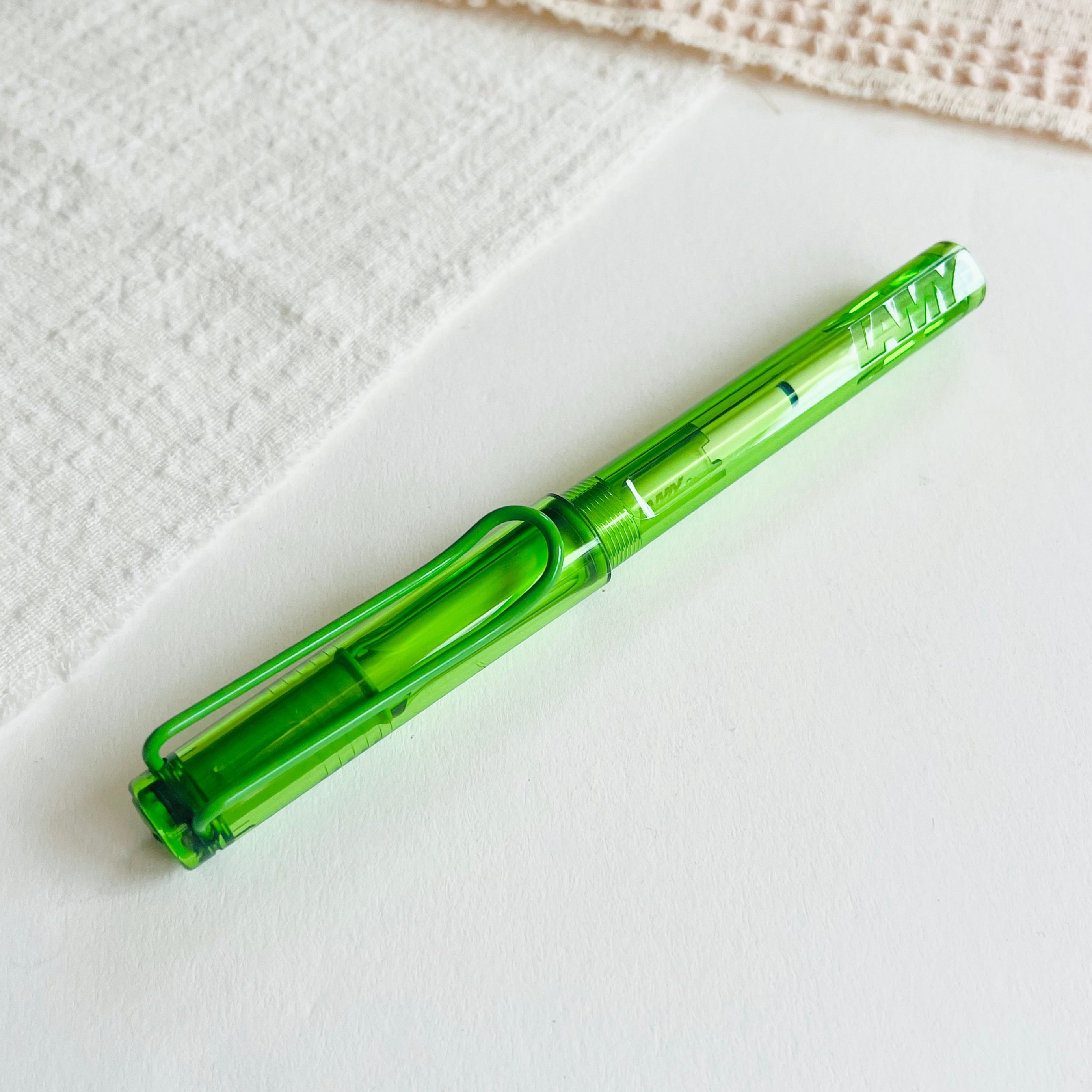 Green pen on a textured white surface